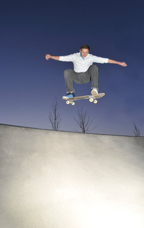 skateboarder flying high at the skate park in summertime の写真素材