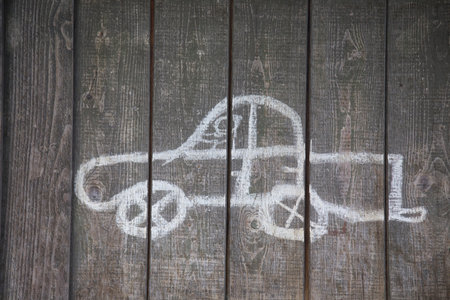 childs drawing of a car on an old wooden wallの写真素材