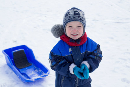 Young boy and his plastic sled