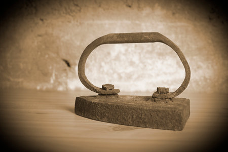 An old vintage rusty iron on a wooden board, sepia toneの写真素材