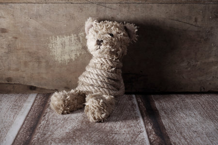 Teddy bear tied up with a rope, bullyingの写真素材