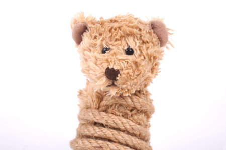 Teddy bear tied up with a rope, bullyingの写真素材
