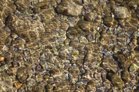 Shallow sea with pebble stones as a background
