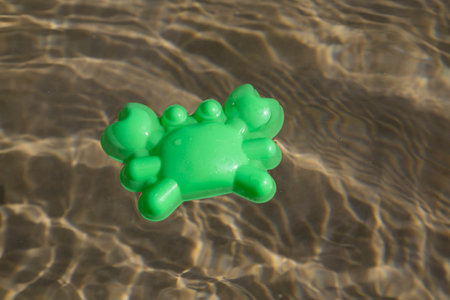 Plastic mould floating in a shallow sea, children toy