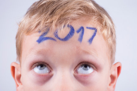 Numeral 2017 on the forehead of a young boy, new year