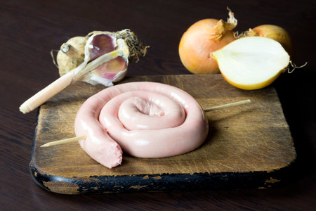 Raw sausage on a wooden chopping boardの写真素材