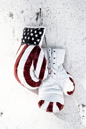Pair of used boxing gloves hanging on a wallの写真素材