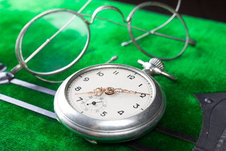 Vintage pocket watch and historical glasses