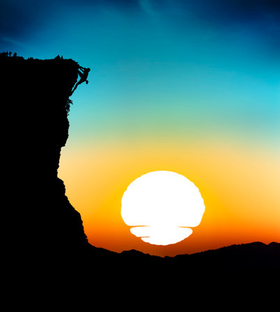 Mountain climb silhouettes with sunset backgroundの写真素材