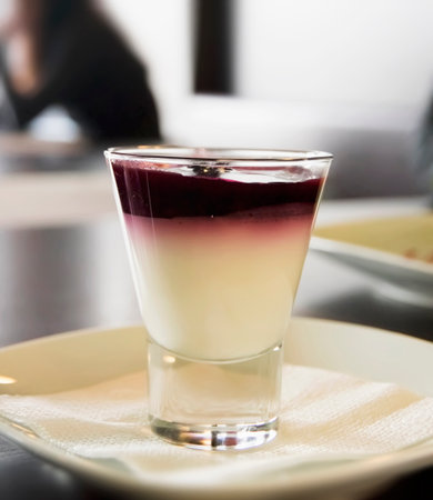 Delicious dessert in tall glasss with cherry jam covering