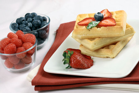 Healthy sweet  decadent belgian waffles garnished with organic berriesの写真素材