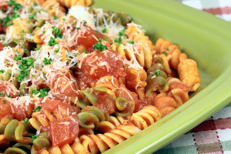 Delicious and perfect made to perfection rainbow rotelli pasta with parmesan cheese and exquisite  fresh organic tomatoes sauce vegans or vegetarians will love it の写真素材