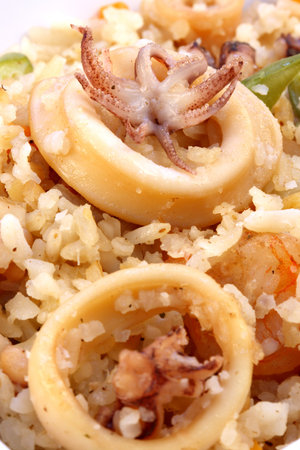 delicious calamary rice with assorted seafood and vegetables served on nice fancy table  の写真素材