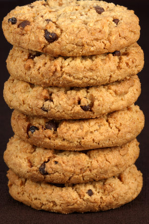 Fresh baked Stack of chocolate chips cookies on fine and fancy brown linen  