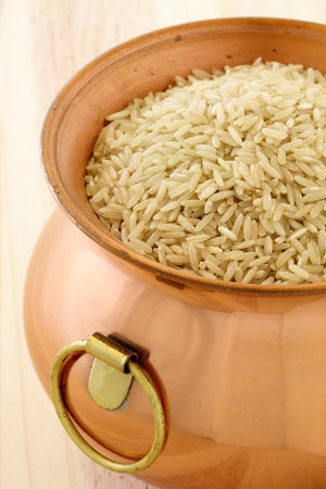 raw brown rice used to make healthy and delicious recipes, on copper potの写真素材
