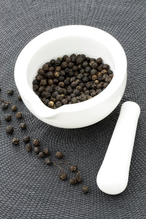 ceramic  mortar and pestle full with aromatic black peppercornsの写真素材