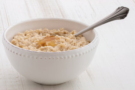Delicious nutritious and healthy fresh old fashioned oatmeal on antique wood tableの写真素材