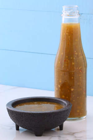 Artisan mexican tomatillo sauce on retro vintage carrara marble setting, with a spicey mild hot flavor perfect for all your Mexican, tex-mex recipes and sides.の写真素材