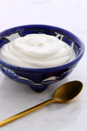 Delicious sour cream a traditional ingredient in France, Russia, Eastern European, German cooking and mexican cuisine. On terracotta or talavera artisan bowlの写真素材
