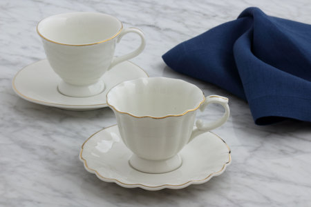trendy and beautiful antique porcelain tea cups styled on carrara marble tableの写真素材