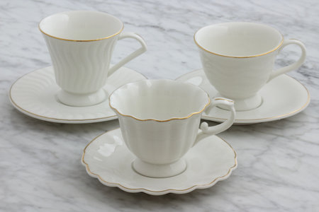 trendy and beautiful antique porcelain tea cups styled on carrara marble tableの写真素材