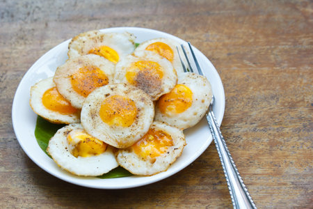 fried quail eggs with sauce and pepper in plate.の写真素材