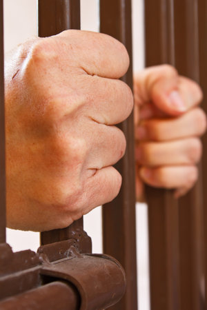 hands behind bars in jail or prison の写真素材