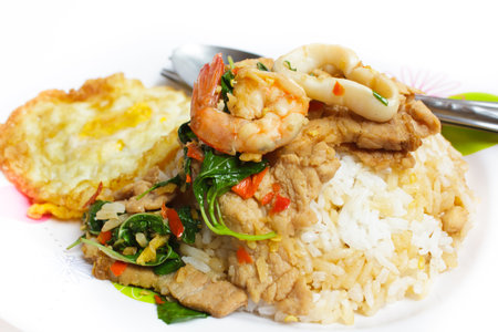 rice and mixed seafood basil with spicy sauce and fried egg, thai food.の写真素材