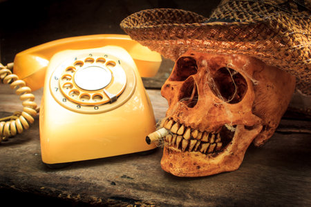 Skull with cigarette, and old wood background.の写真素材