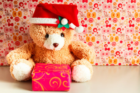 teddy bear wearing a santa hat and gift.の写真素材
