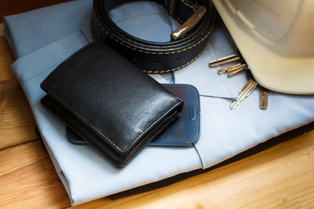 workwear, boots and wallet and mobile on wooden table.の写真素材