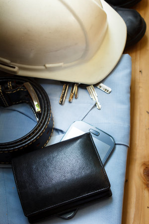 workwear, boots and wallet and mobile on wooden table.の写真素材