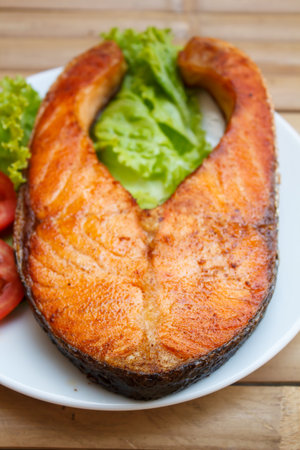 salmon steak with tomato and lettuce at restaurant.の写真素材