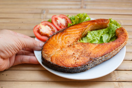 salmon steak with tomato and lettuce at restaurant.の写真素材