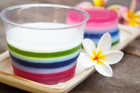 colorful coconut jelly, thai dessert on old wood background.の写真素材