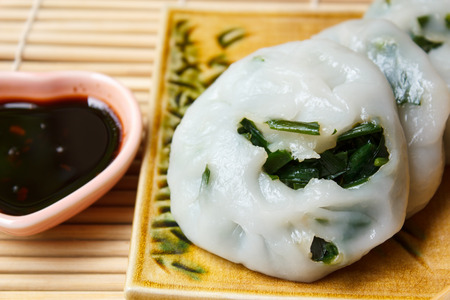 Steamed dumpling stuffed with garlic chives served with sweet black sauce.の写真素材