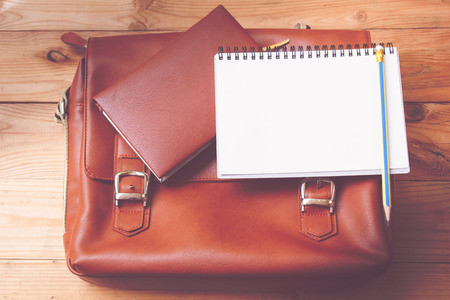 leather female bag with note book on wood background.の写真素材