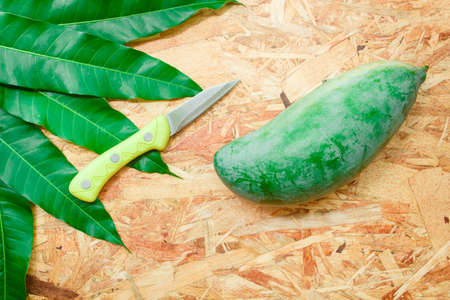 Mango and leaf on the wooden background.の写真素材