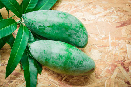 Mango and leaf on the wooden background.の写真素材