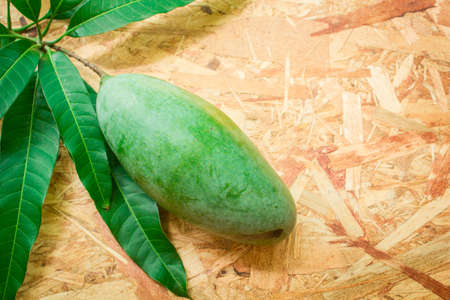 Mango and leaf on the wooden background.の写真素材