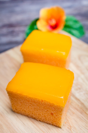 Orange cake two square pieces on wooden background.の写真素材