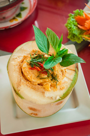 Steamed fish and seafood with curry paste in coconut on table.の写真素材