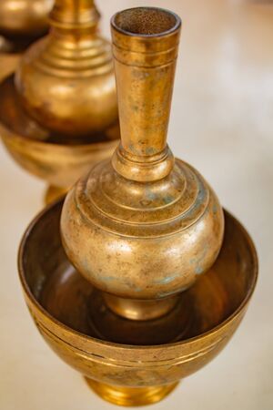 A golden brass pour ceremonial water jar in Thai traditional pouring.の写真素材