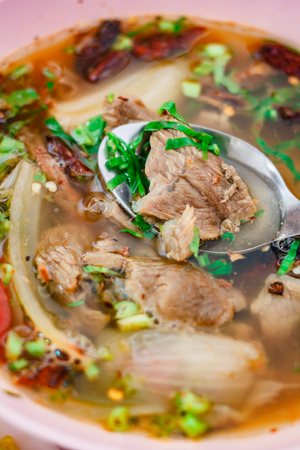 Delicious hot spicy soup with meat in a bowl, Thai food style.の写真素材