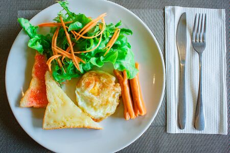 American breakfast with eggs, toast and sausage at restaurant.の写真素材