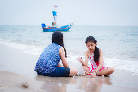 two little girls are on the beach, thai girl.の写真素材