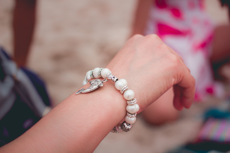 pearl bracelet and silver on woman's hand.