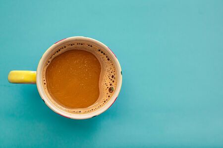 A cup of coffee on blue desk. Invigorating coffee.