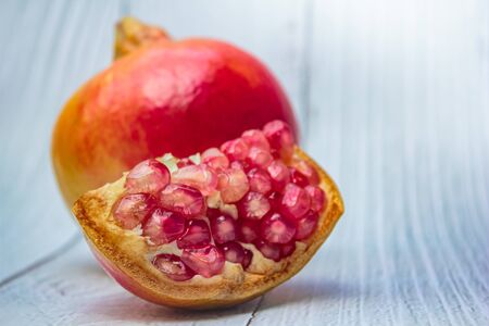 Pomegranate fresh fruit on wood white background, Pomegranates (Punica granatum) is a fruit-bearing...