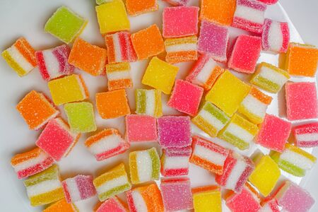 A pile of fruity gummy jelly sweets on white plate background.の写真素材